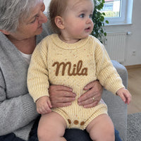 Oma mit ihrer Enkelin auf dem Schoss, im Strampler