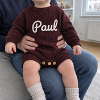 Vater mit seinem Baby auf dem Schoss, im Strampler
