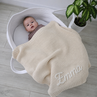 Baby im Stubenkorb mit gestrickter Babydecke in Creme, Name Emma von Hand im Kettenstich bestickt