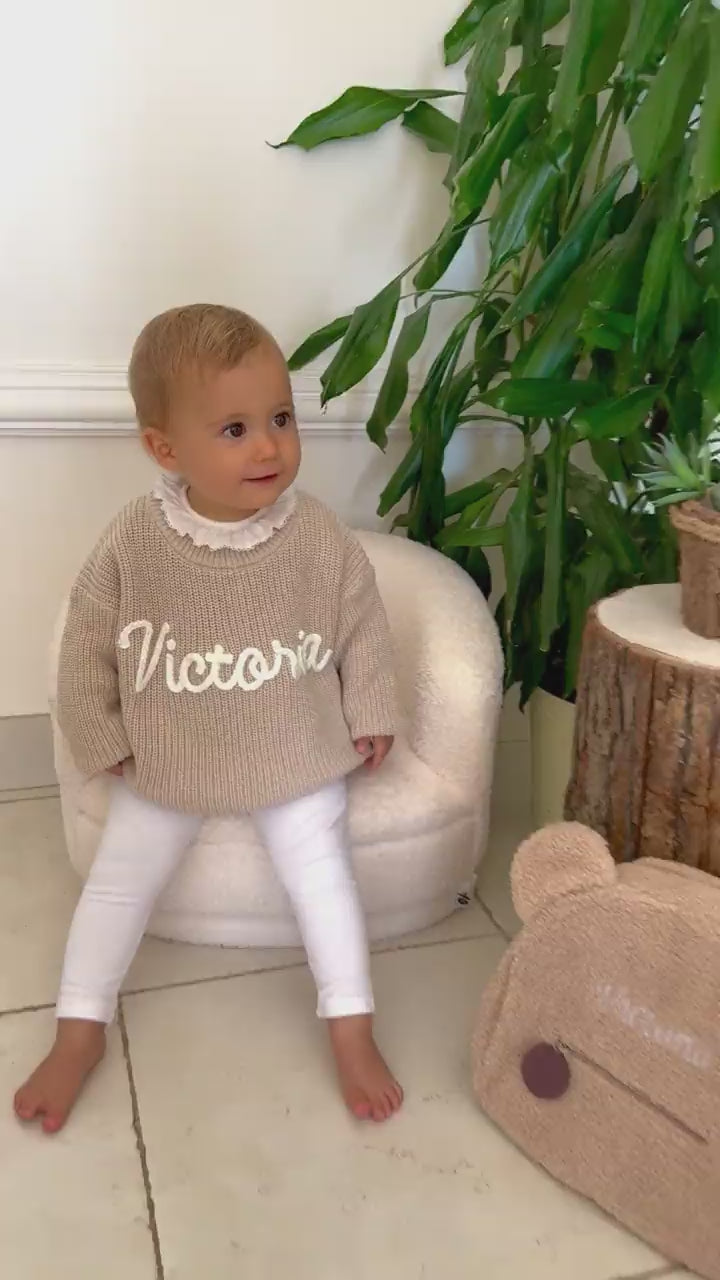 Kleinkind jubelt im Pullover mit dem Namen Victoria